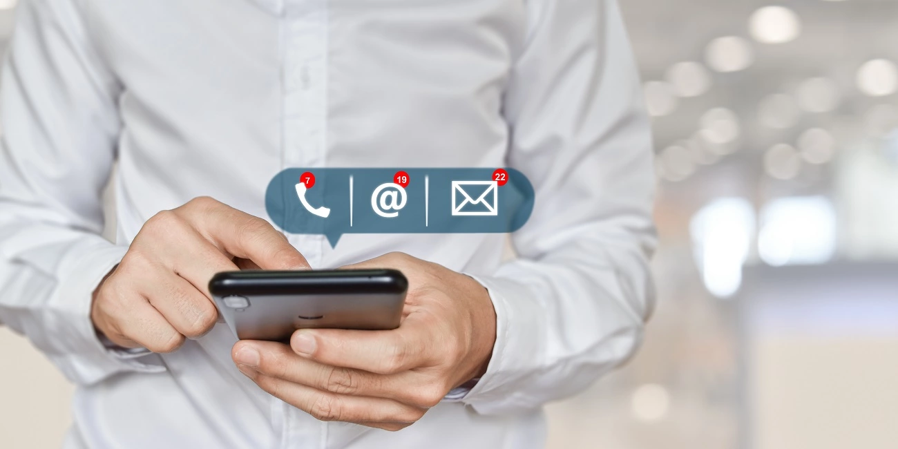 Бизнесмен, който държи мобилен телефон с контактна информация